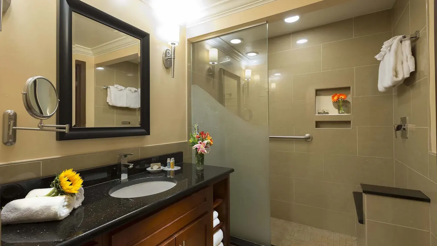 Guest bathroom with vanity and glass shower at Divi Village Golf & Beach Resort.