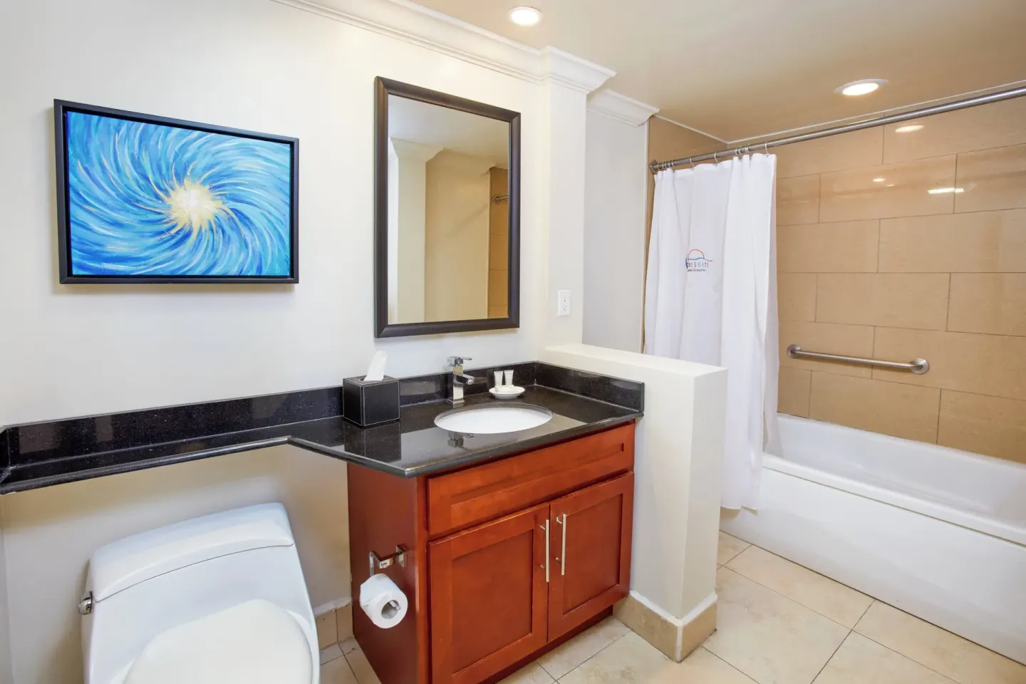 Guest bathroom with tub, vanity, and wall art at Divi Village Golf & Beach Resort.