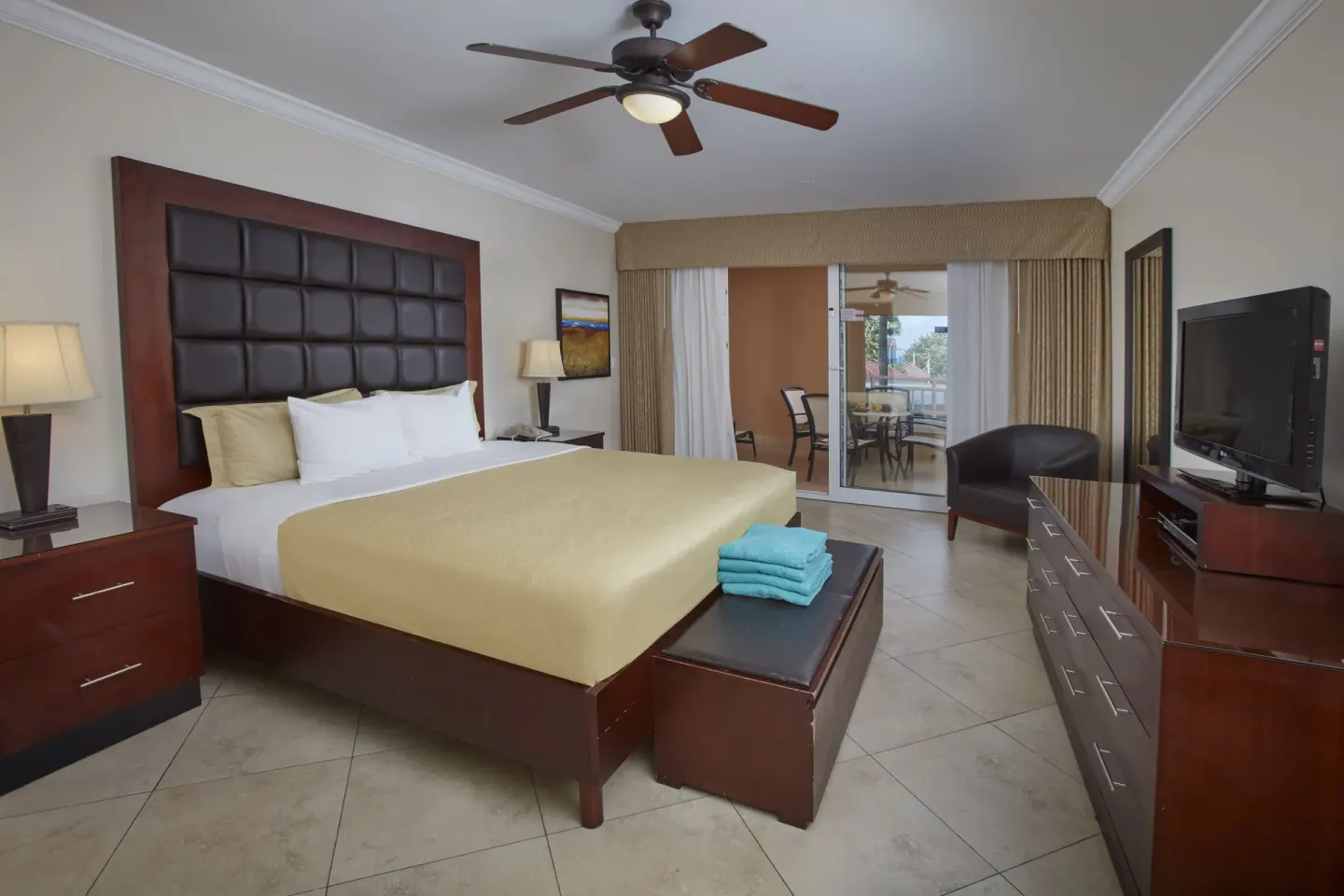 Guest room with king bed and balcony seating at Divi Village Golf & Beach Resort.