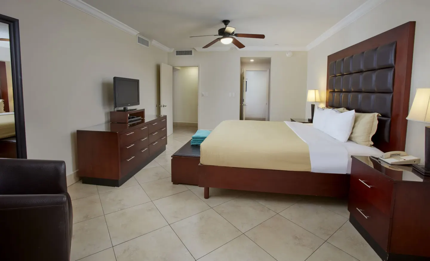 Guest room with king bed, dresser and lounge chair at Divi Village Golf & Beach Resort.