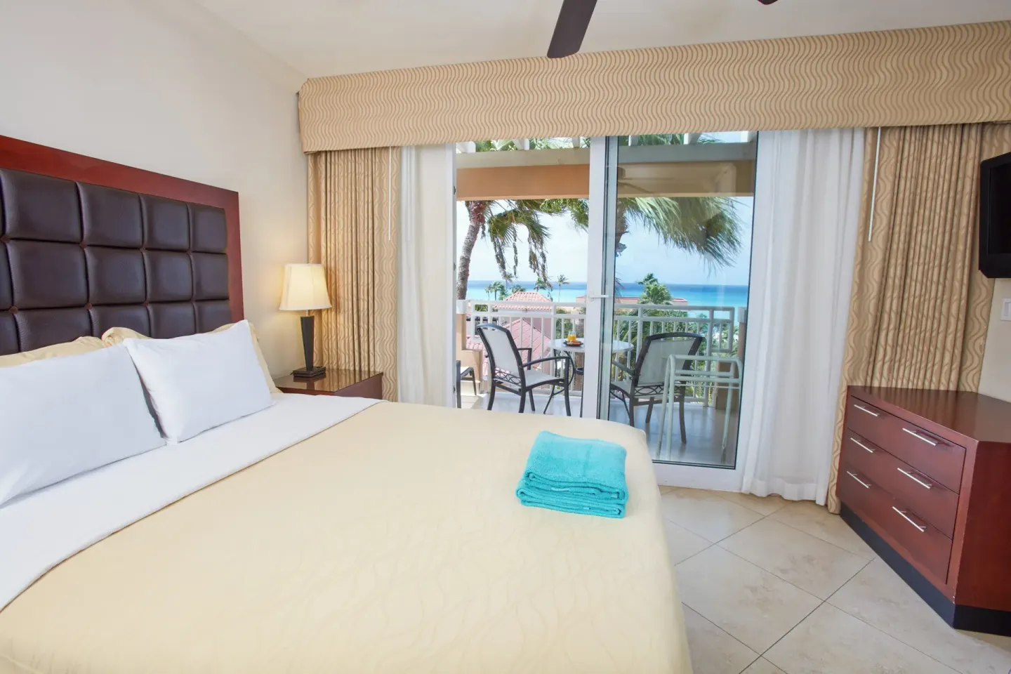 Guest room with king bed and ocean-view balcony at Divi Village Golf & Beach Resort.