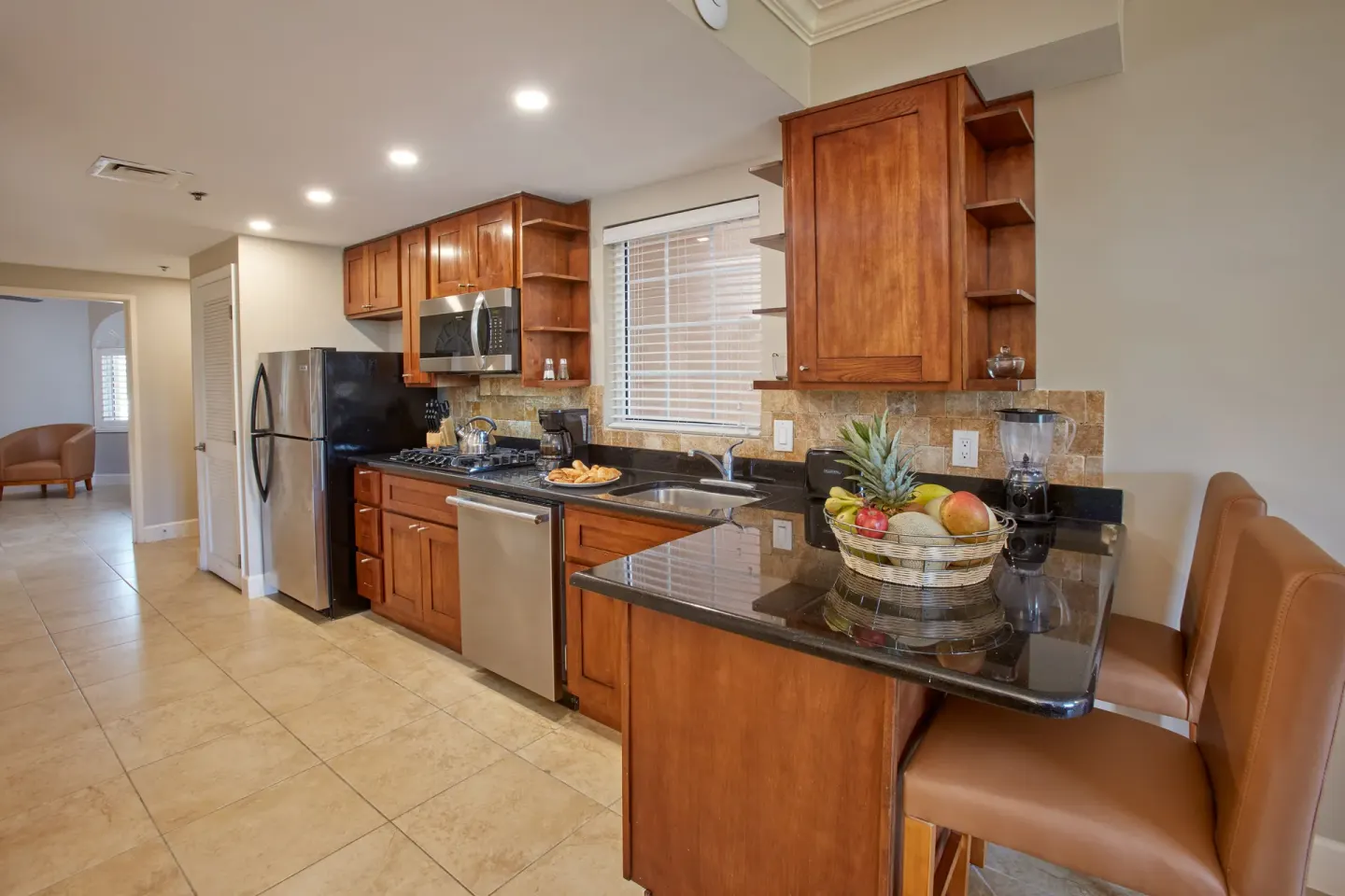 Guest room kitchen with wood cabinets and breakfast bar at Divi Village Golf & Beach Resort.