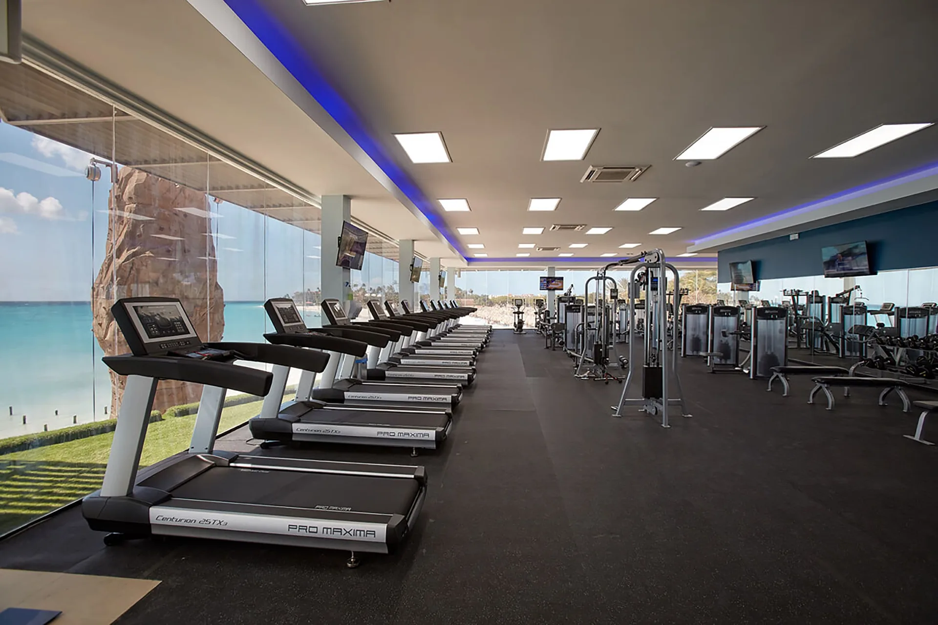 Fitness center with treadmills and ocean-facing windows at Divi Village Golf & Beach Resort.