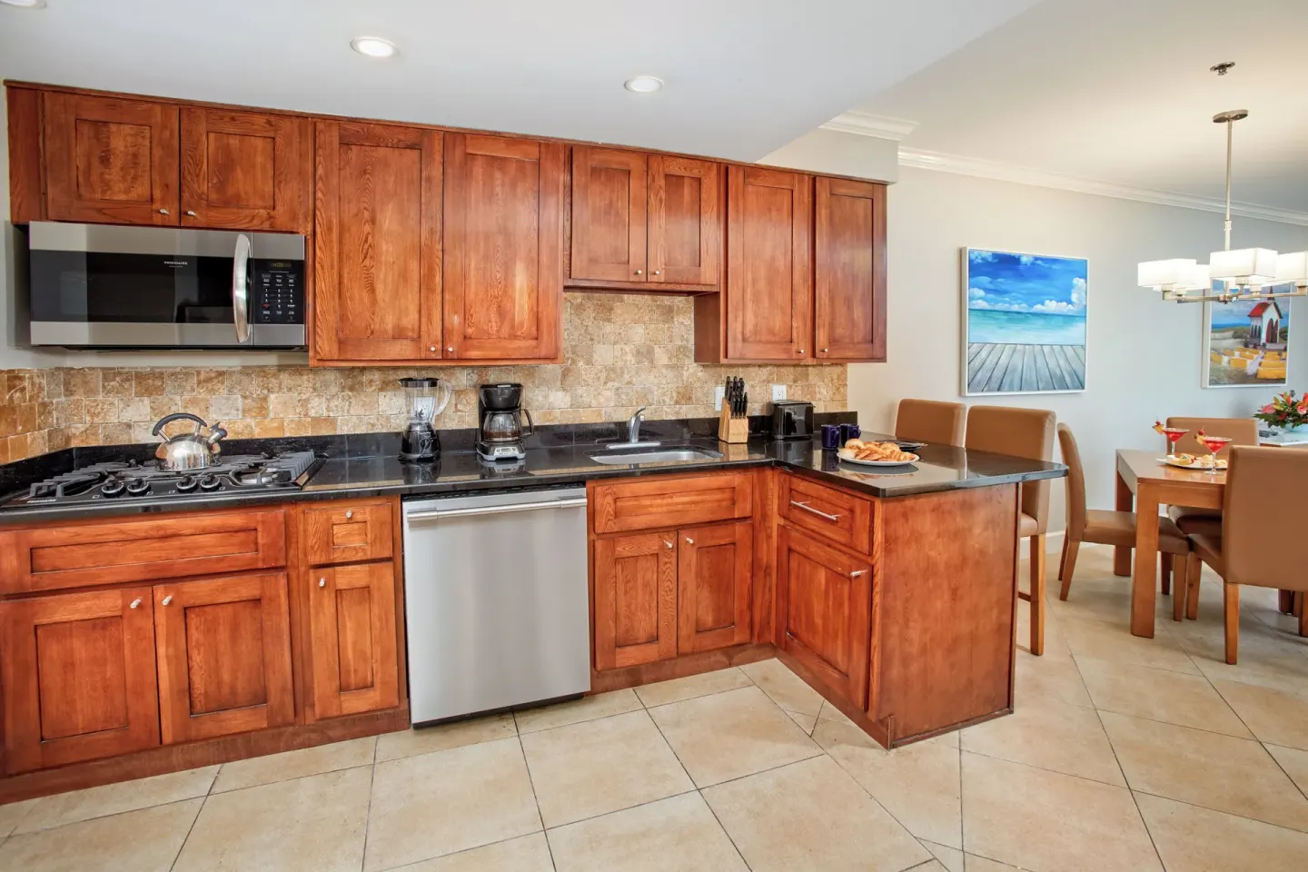 Suite kitchen and dining area at Divi Village Golf & Beach Resort with wood cabinets and table seating.