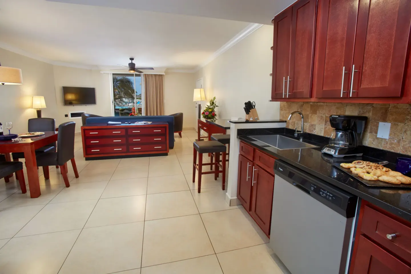 Suite kitchen at Divi Village Golf & Beach Resort opening to a living room with a window view.