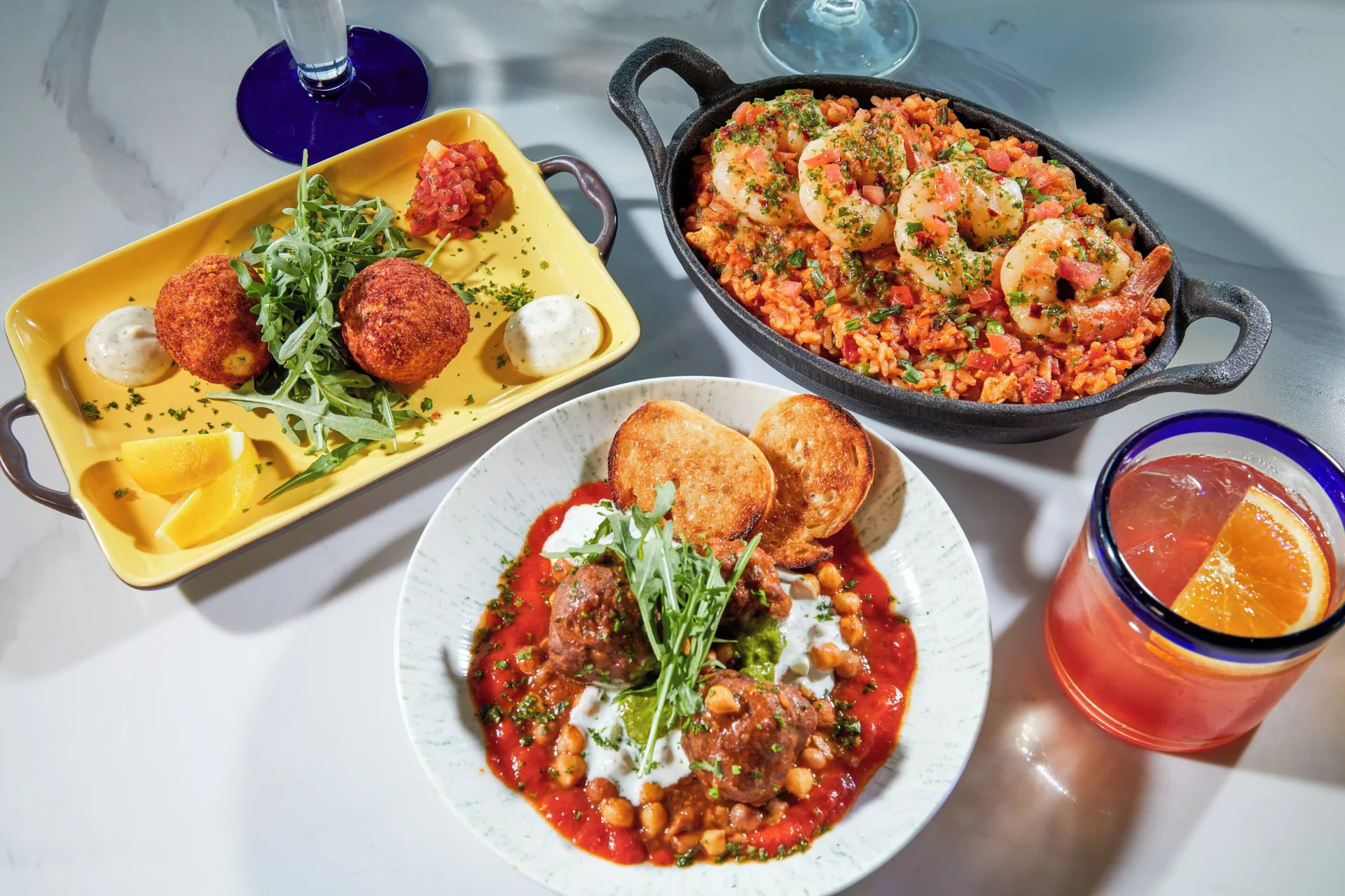 Tapas plates and cocktails are arranged on a tabletop at Divi Village Golf & Beach Resort.