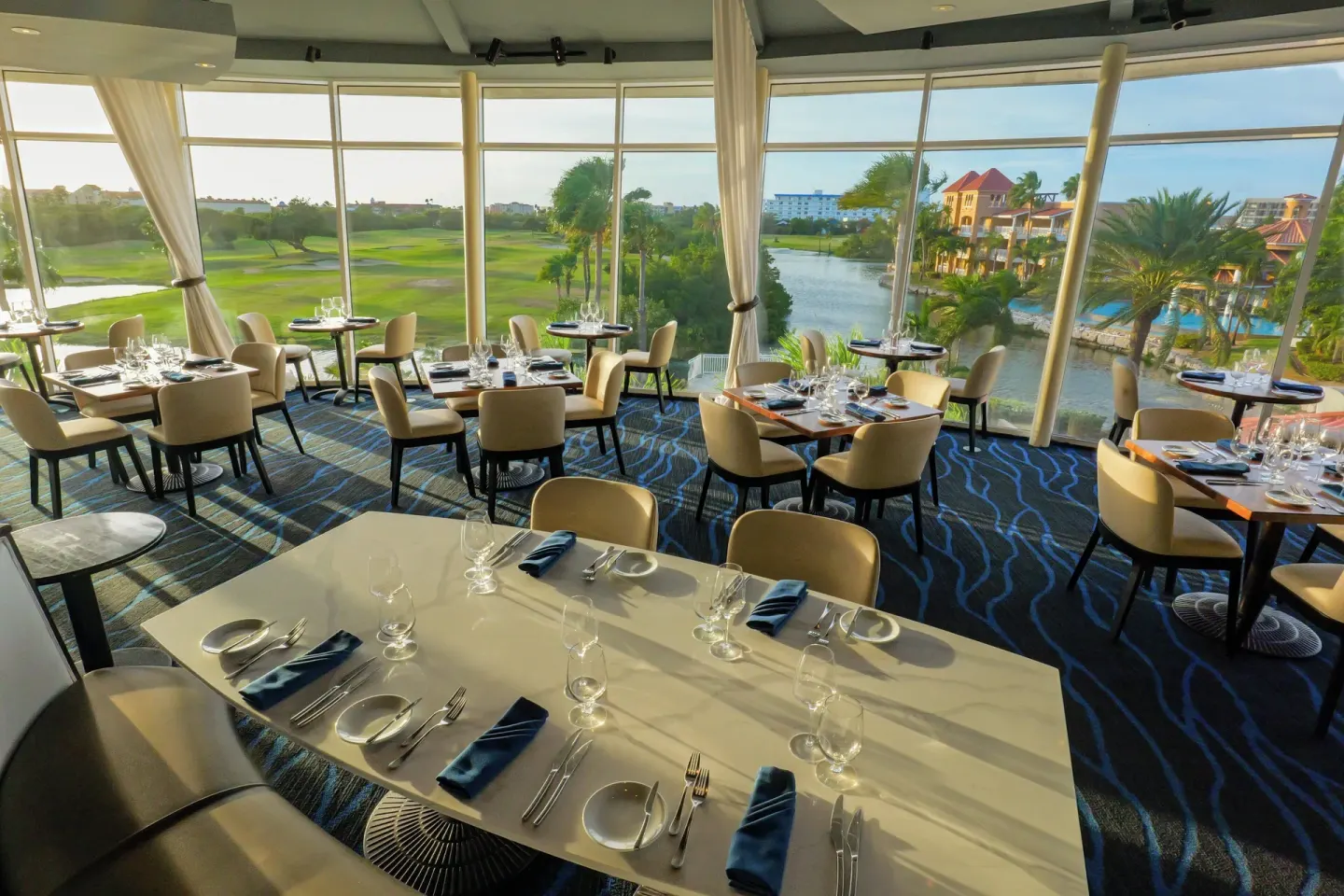 Window-lined dining room with golf course and lagoon views at Divi Village Golf & Beach Resort.
