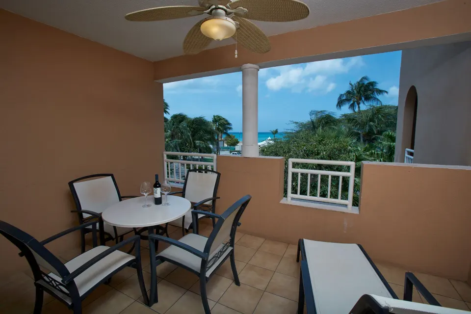 Studio Suite balcony with seating and ocean view at Divi Village Golf & Beach Resort.