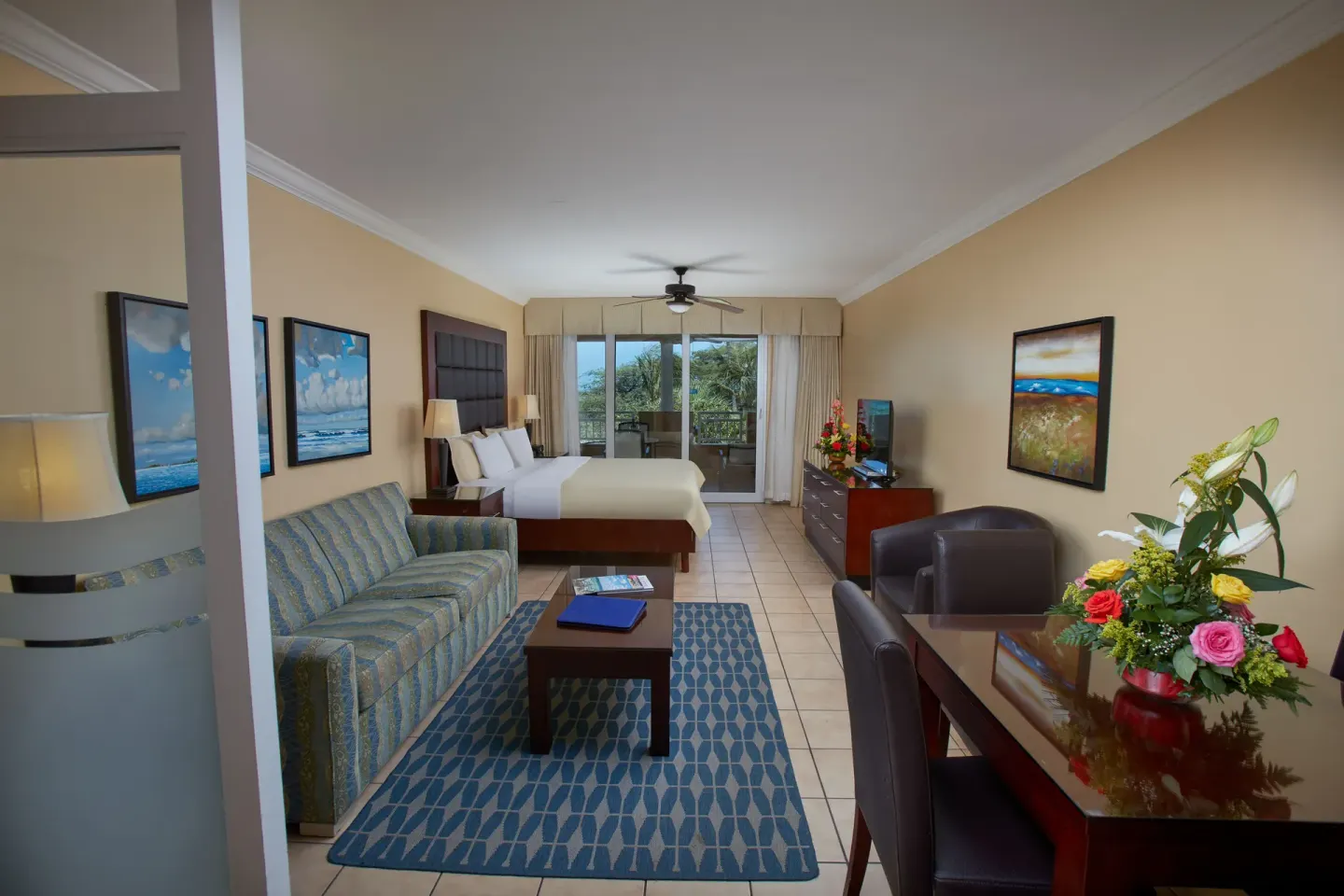 Studio Suite with king bed, sofa, dining table, and balcony at Divi Village Golf & Beach Resort.