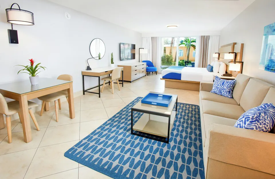 Studio Suite living area with sofa and king bed at Divi Village Golf & Beach Resort.