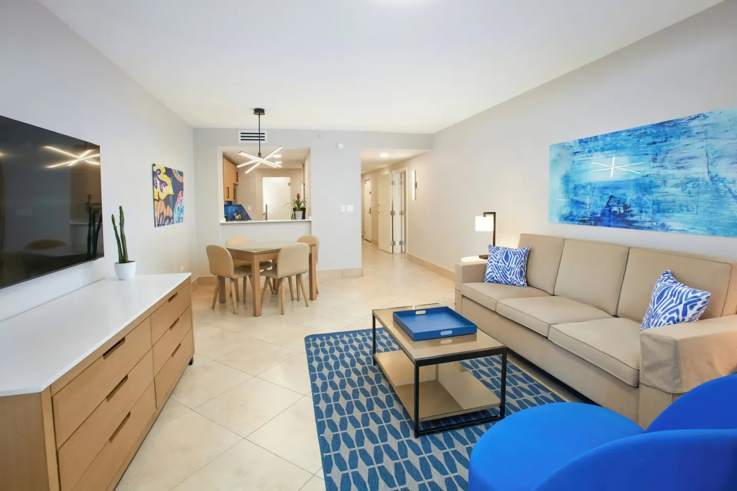 One Bedroom Suite living room with sofa, dining table and TV at Divi Village Golf & Beach Resort.