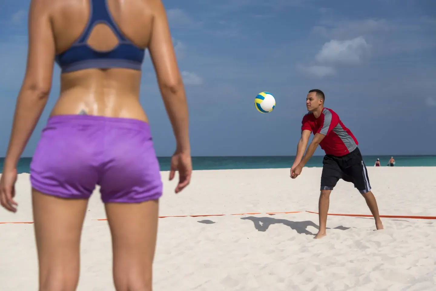 Guests play beach volleyball on white sand near Divi Village Villas.