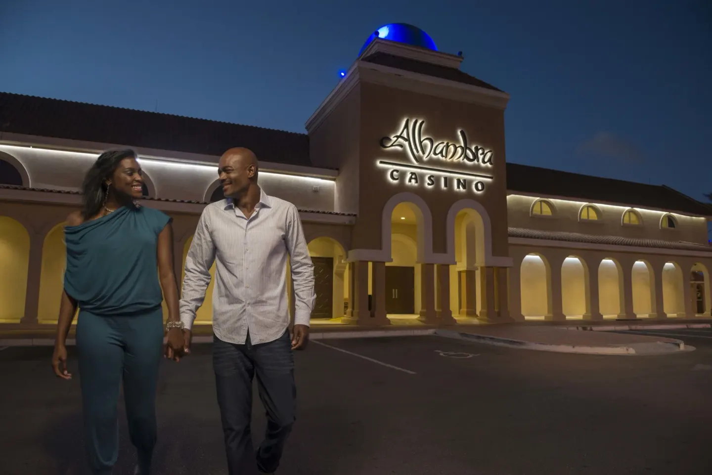 Couple walking outside the illuminated casino entrance at Divi Village Villas.