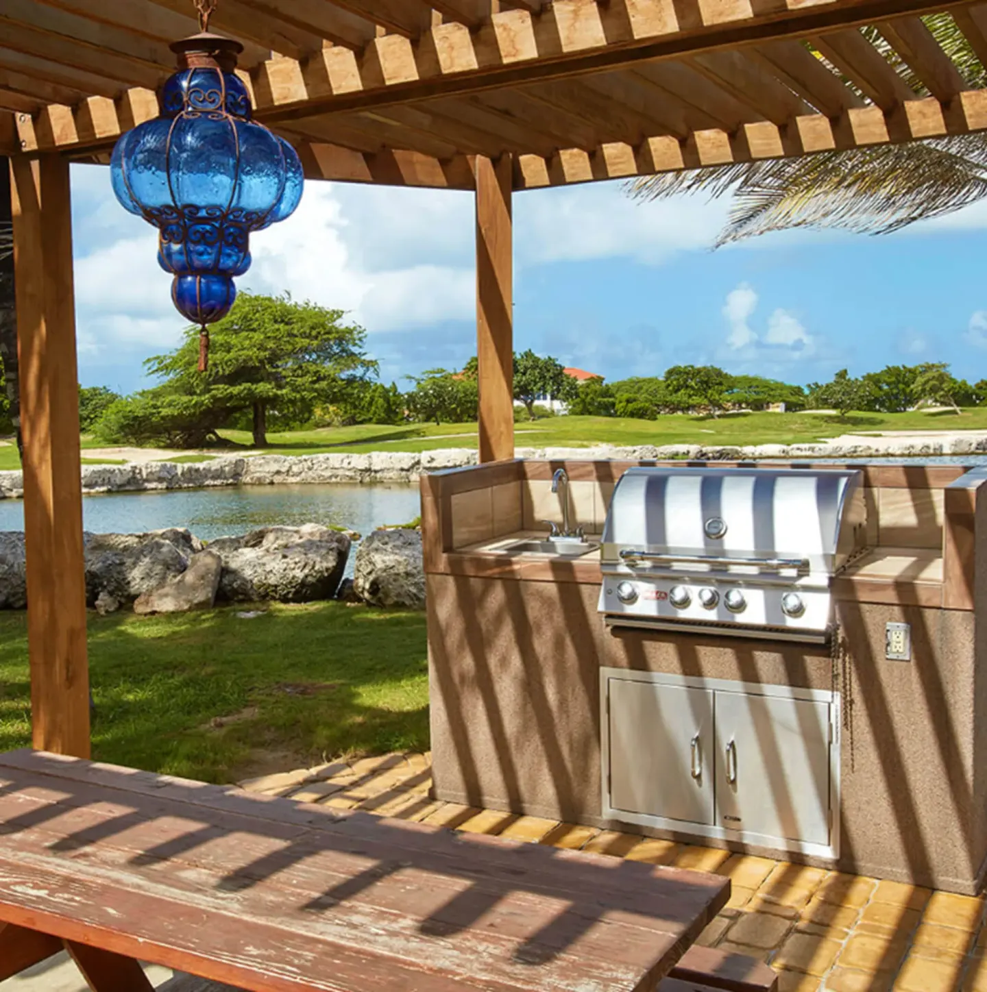 Covered outdoor grill area overlooking water and golf greens at Divi Village Villas.