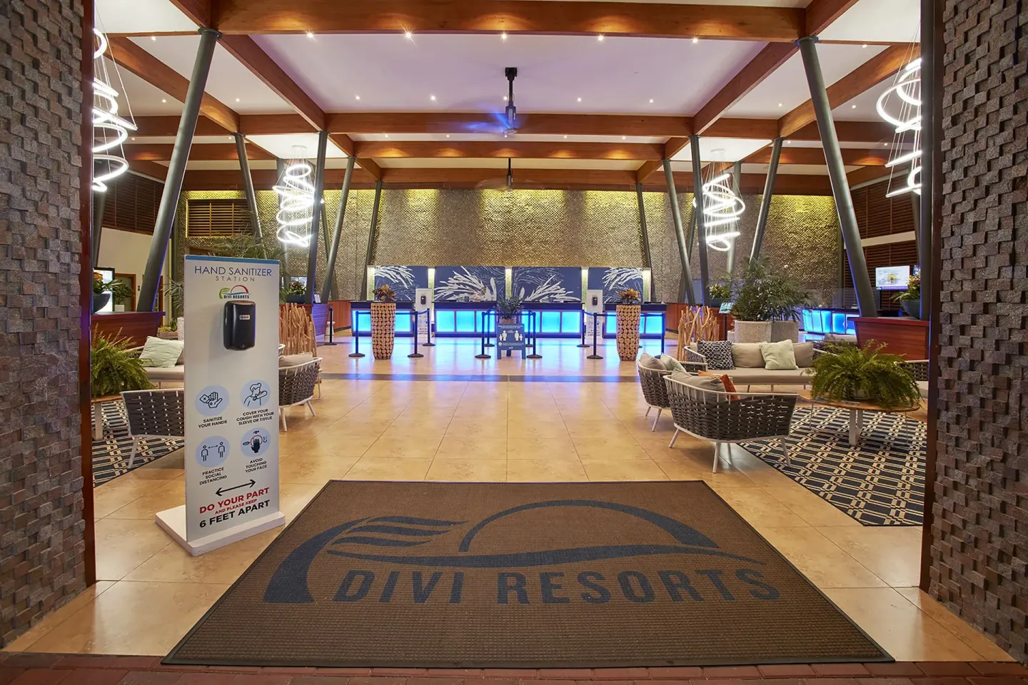Lobby entrance with welcome mat, sanitizer station, and reception desks at Divi Village Villas.