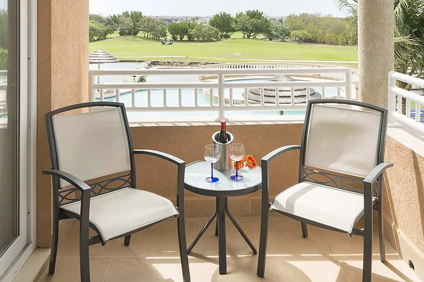 Studio Suite Golf View balcony at Divi Village Villas with two chairs and a golf course view.