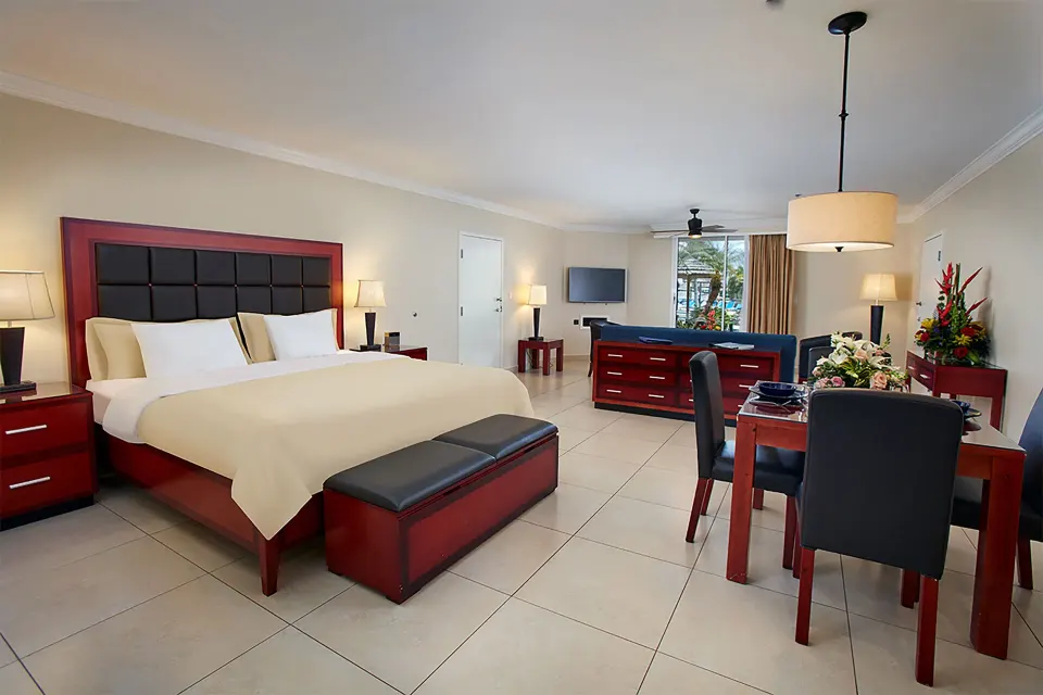 Studio suite with king bed, dining table, dresser, TV, and sitting area at Divi Village Villas.