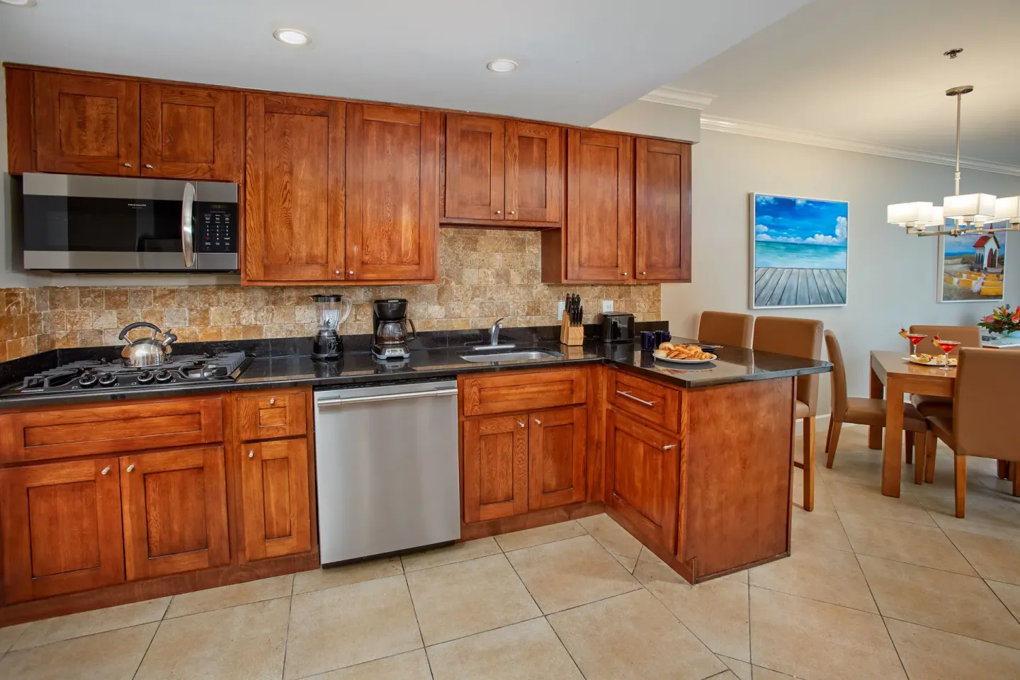 Kitchen in a Studio Suite Golf View at Divi Village Villas with wood cabinets and dining area.