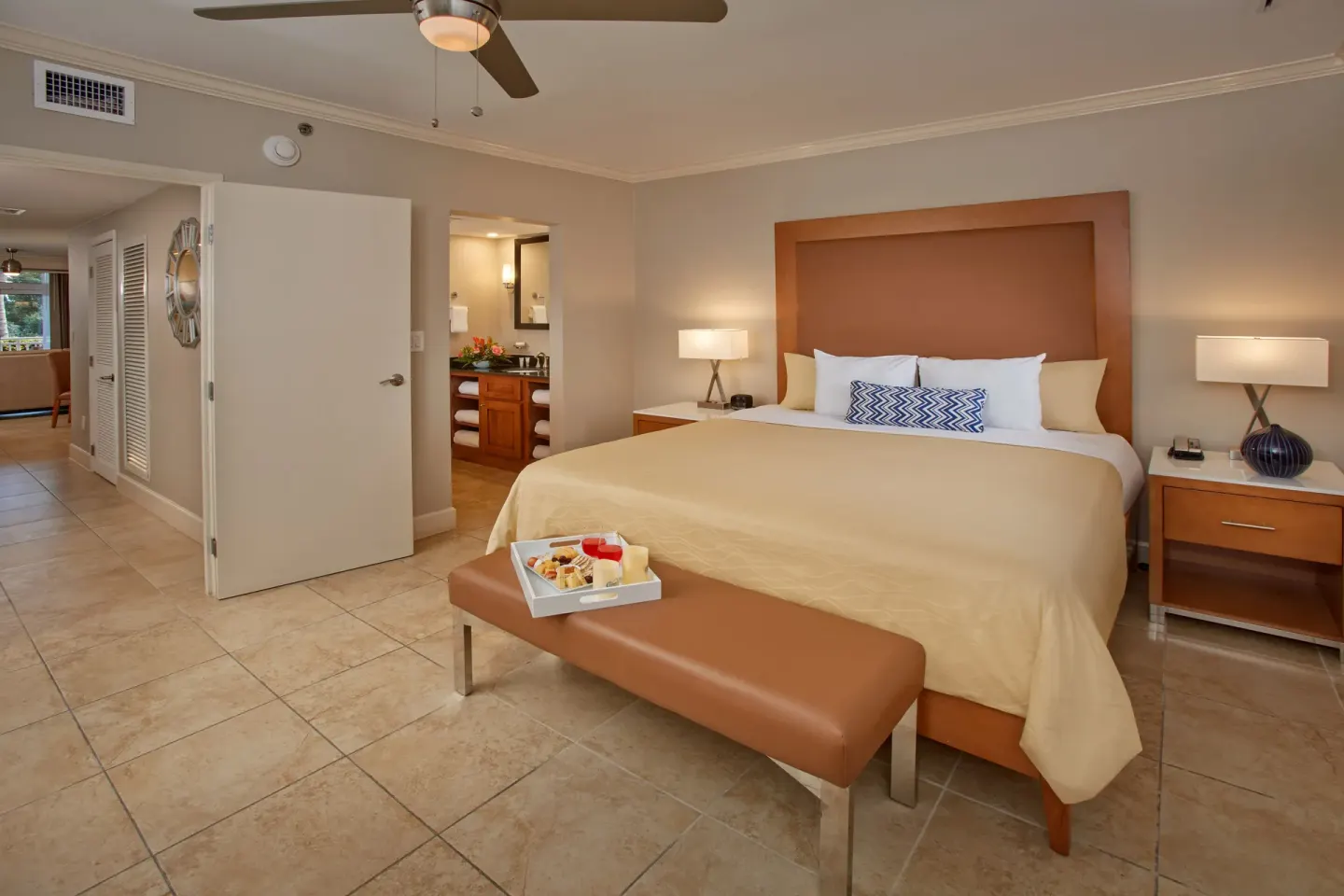 One-bedroom suite king bed with open bathroom door at Divi Village Villas.