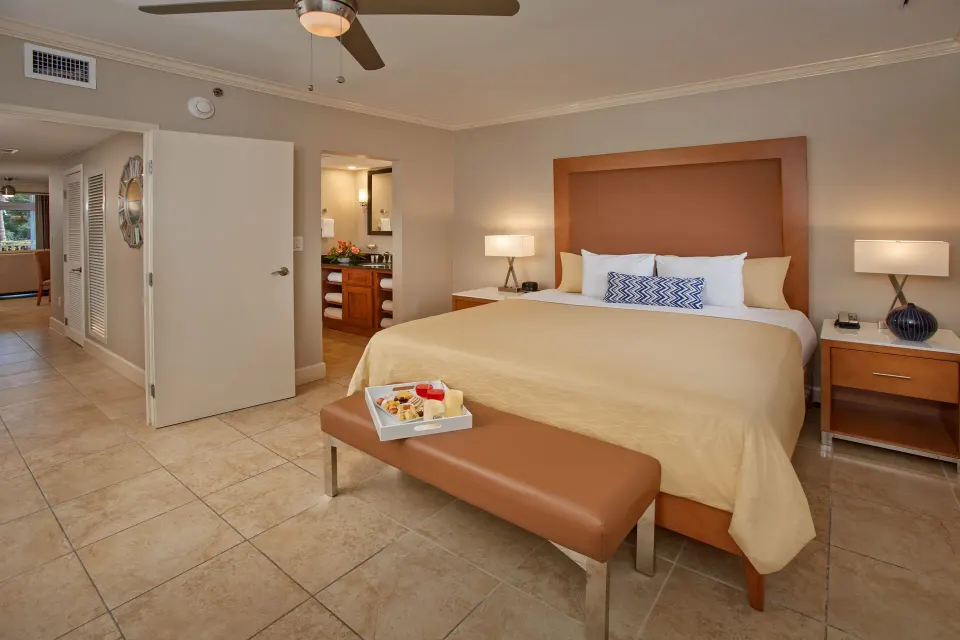 One-bedroom suite king bed with open bathroom door at Divi Village Villas.