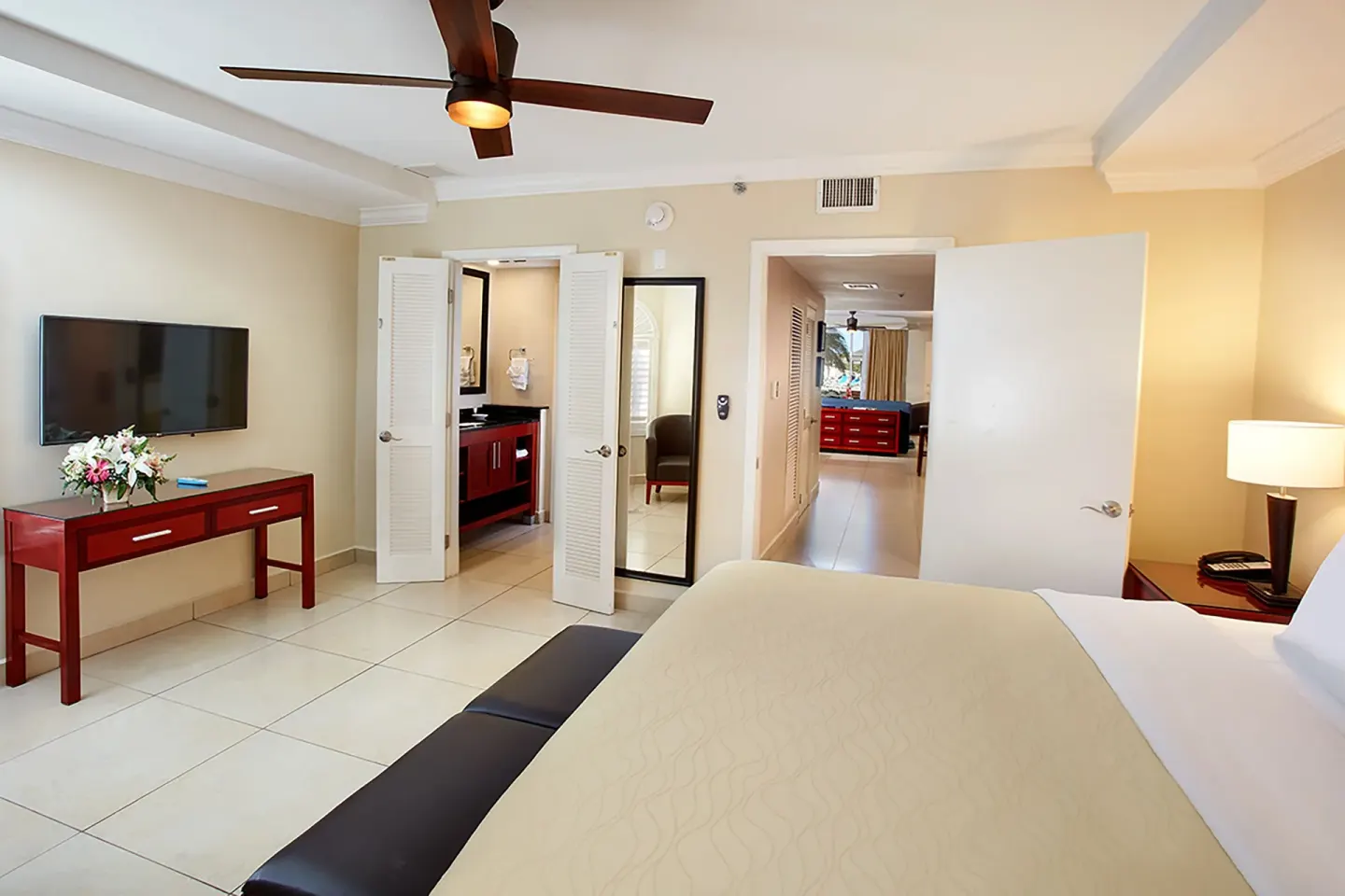 King bedroom looking toward the bathroom, hallway, and wall-mounted TV at Divi Village Villas.