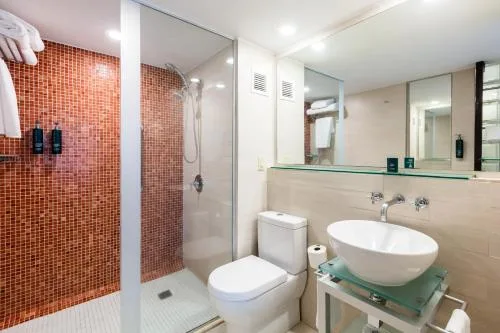 Higher Floor room bathroom with glass shower, vessel sink, and toilet at DoubleTree San Juan.