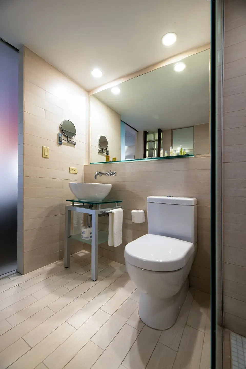 Standard Room bathroom at DoubleTree San Juan with a toilet, vessel sink, mirror, and tiled floor.