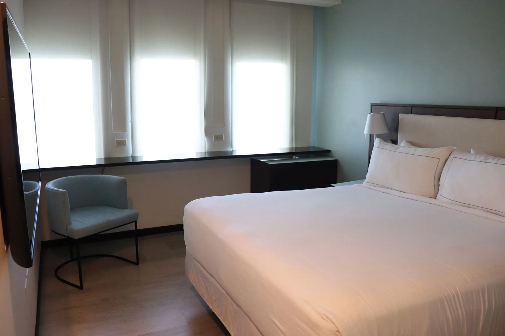 Standard Room with king bed, chair, and bright windows at DoubleTree San Juan.