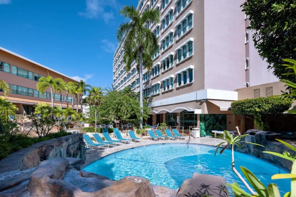 Outdoor pool courtyard with lounge chairs beside the tower at DoubleTree San Juan.