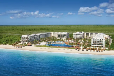 Aerial beachfront view of Dreams Riviera Cancun Resort & Spa beside the turquoise Caribbean Sea.