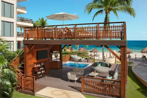 Two-level beachfront deck lounge at Dreams Riviera Cancun Resort & Spa with ocean views and seating.