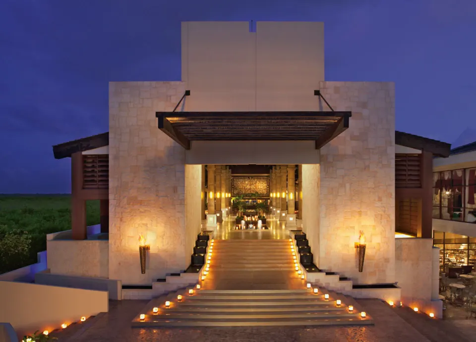 Candlelit resort entrance at dusk at Dreams Riviera Cancun Resort & Spa.