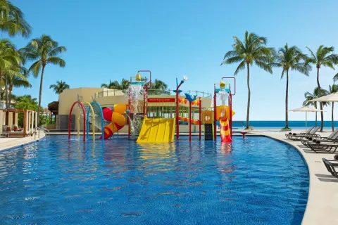 Children's splash pool with slides at Dreams Riviera Cancun Resort & Spa.