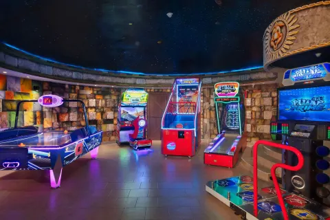 Neon-lit arcade games in the game room at Dreams Riviera Cancun Resort & Spa.