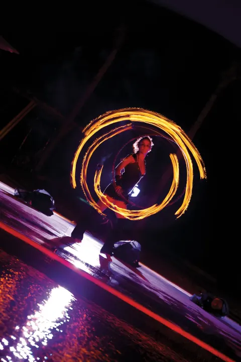 Fire dancer performing at night by the pool at Dreams Riviera Cancun Resort & Spa.