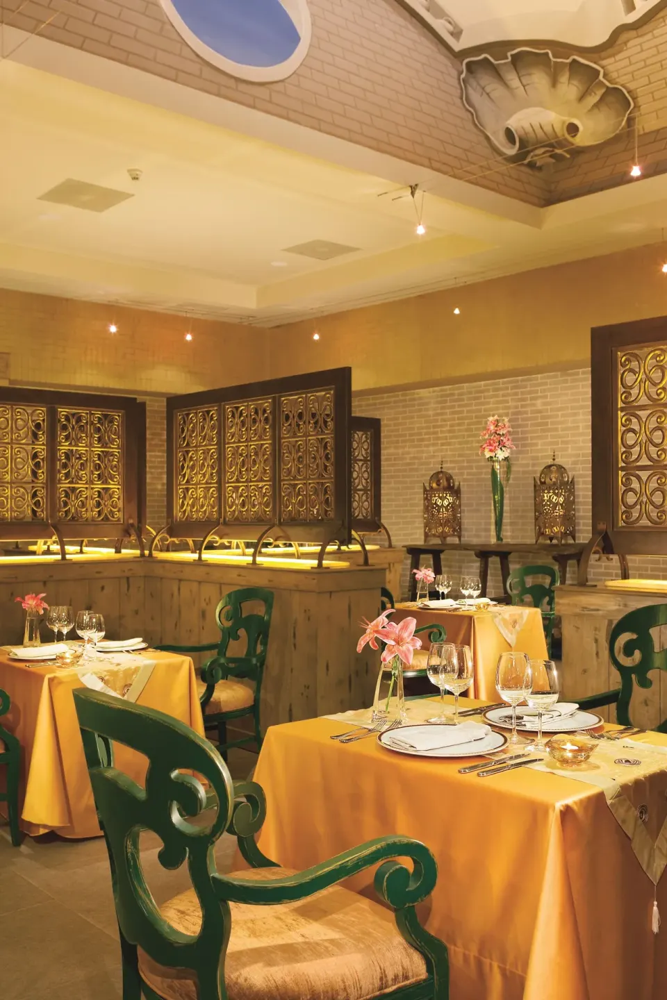 Elegant restaurant tables with yellow linens at Dreams Riviera Cancun Resort & Spa.