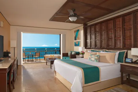 premium Ocean Front Honeymoon Suite bedroom at Dreams Riviera Cancun Resort & Spa with balcony view.