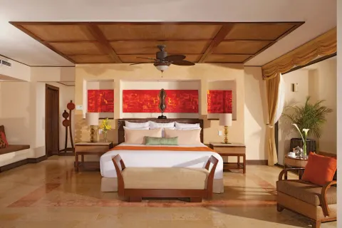 Presidential suite bedroom with king bed at Dreams Riviera Cancun Resort & Spa.