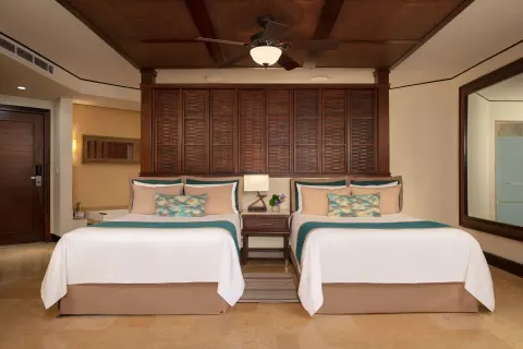 premium Tropical View room with two beds and wood headboard at Dreams Riviera Cancun Resort & Spa.