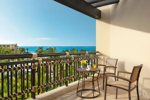 Premium Deluxe Ocean View balcony at Dreams Riviera Cancun Resort & Spa with seating and a sea view.
