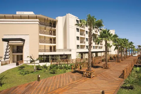 Guest-room building and palm-lined boardwalk at Dreams Riviera Cancun Resort & Spa.