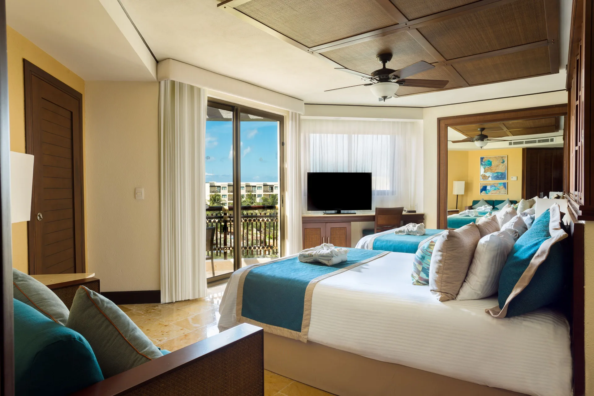 Guest room with two double beds and balcony at Dreams Riviera Cancun Resort & Spa.