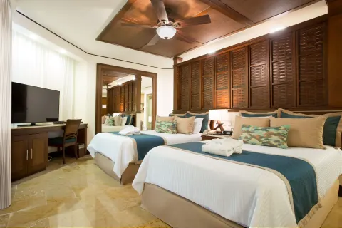 Guest room with two double beds and wood headboard at Dreams Riviera Cancun Resort & Spa.