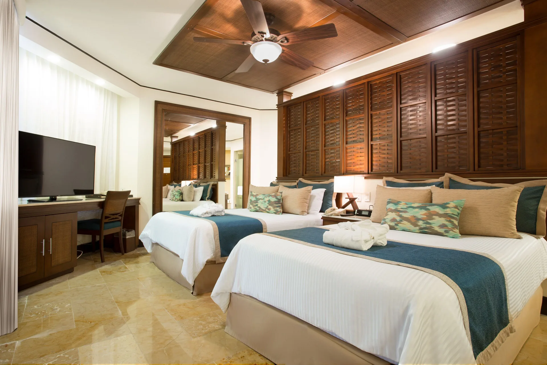 Guest room with two double beds and wood headboard at Dreams Riviera Cancun Resort & Spa.