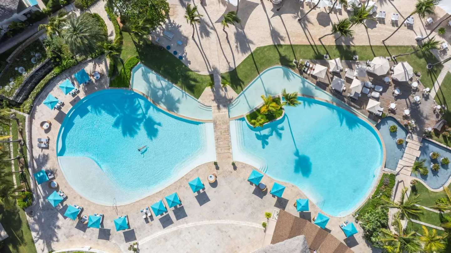 Aerial view of the pool deck with palms and loungers at Eden Roc Cap Cana.
