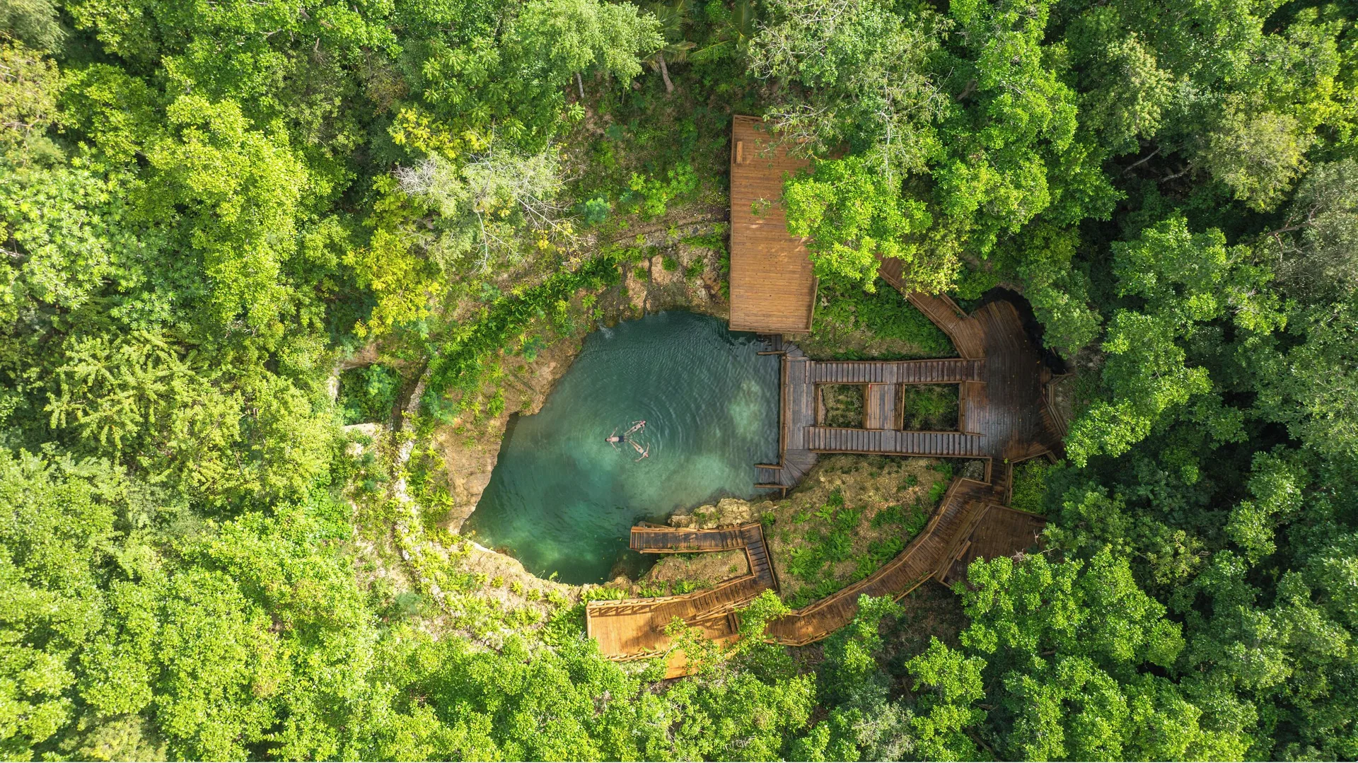 Aerial view of a forest cenote with wooden decks at Eden Roc Cap Cana.