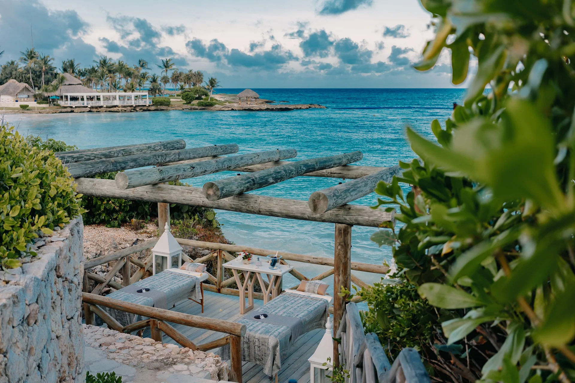 An ocean-view spa terrace with two treatment beds sits above the water at Eden Roc Cap Cana.