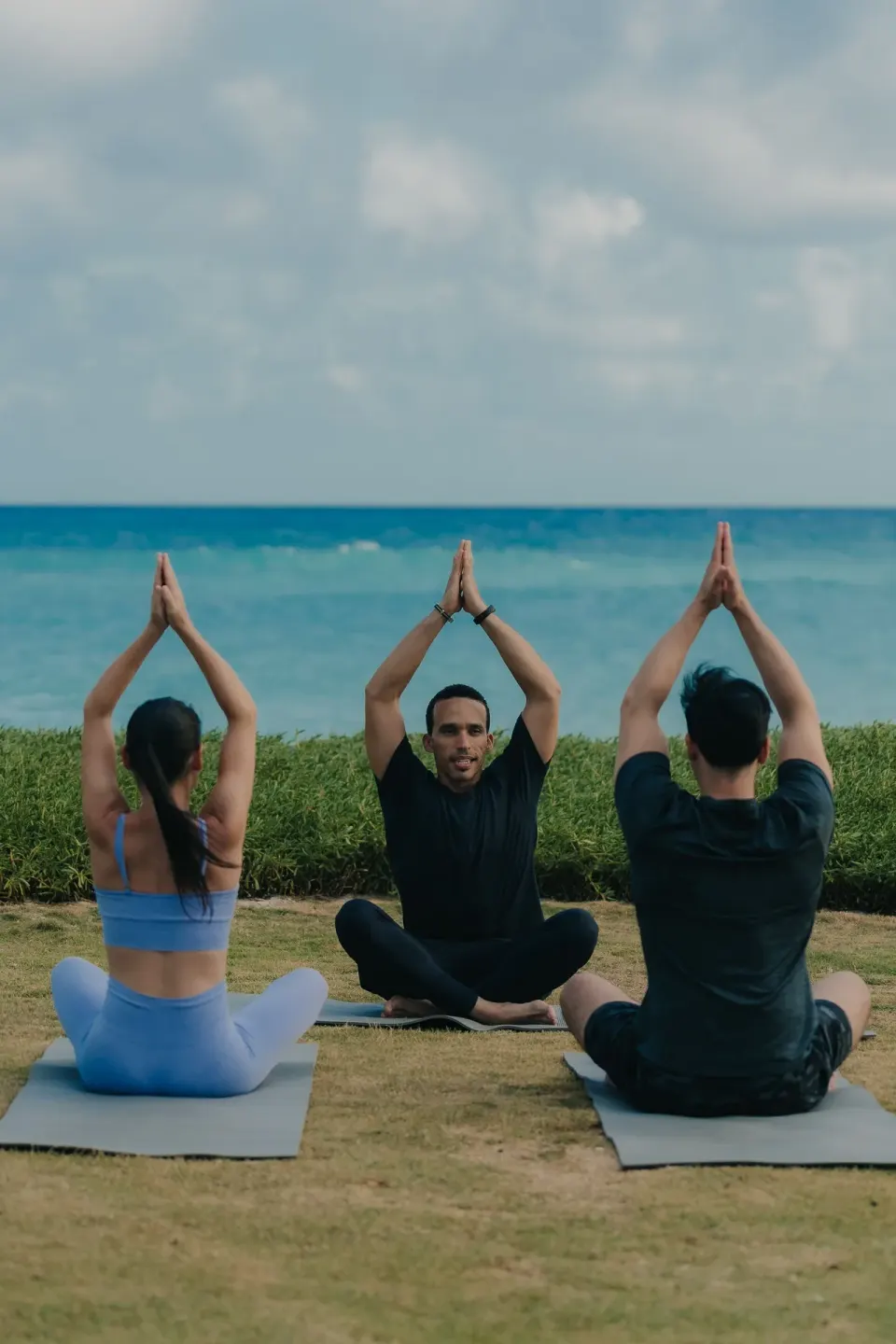 Small yoga class seated on mats facing the ocean at Eden Roc Cap Cana.