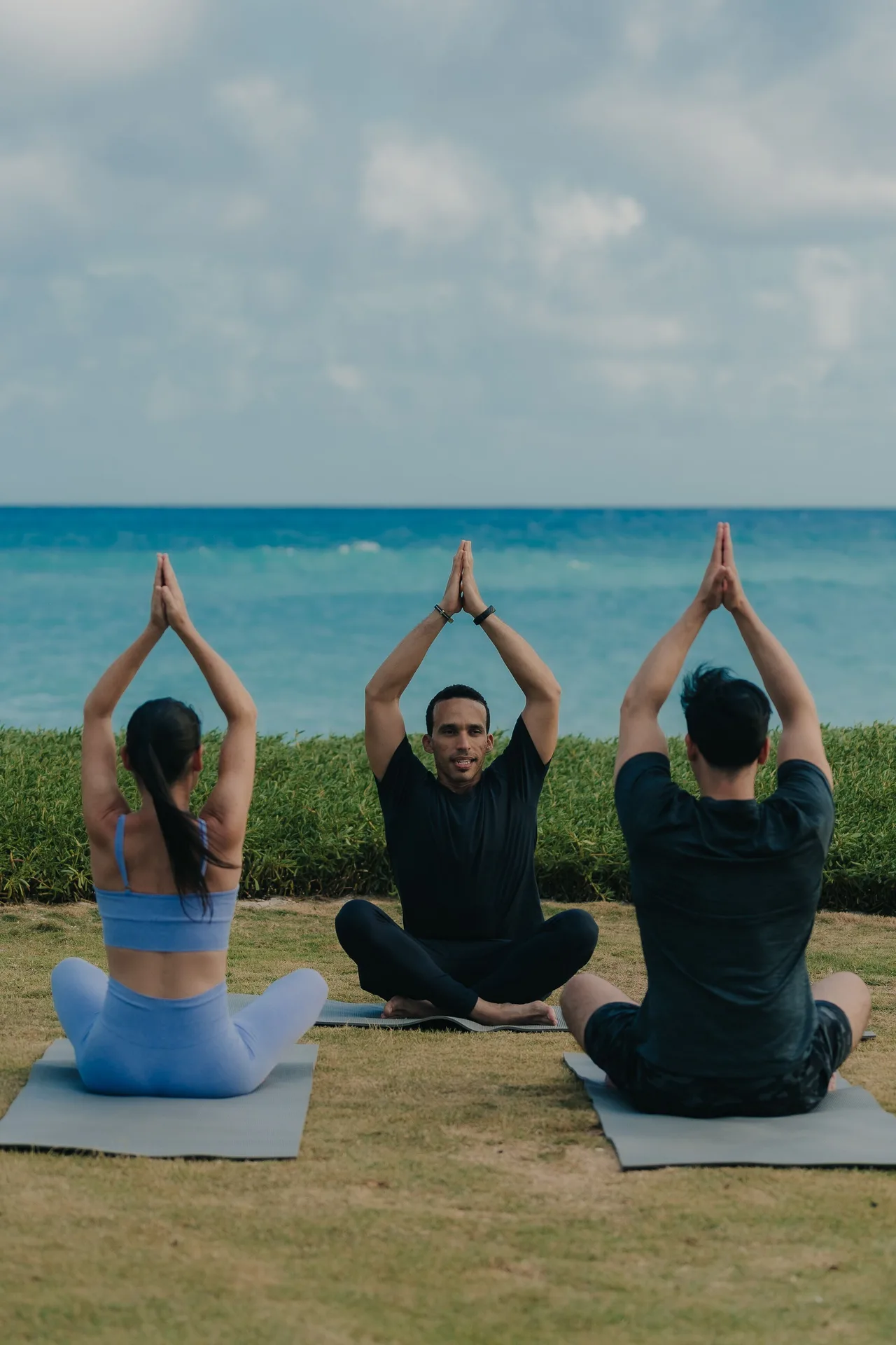 Small yoga class seated on mats facing the ocean at Eden Roc Cap Cana.
