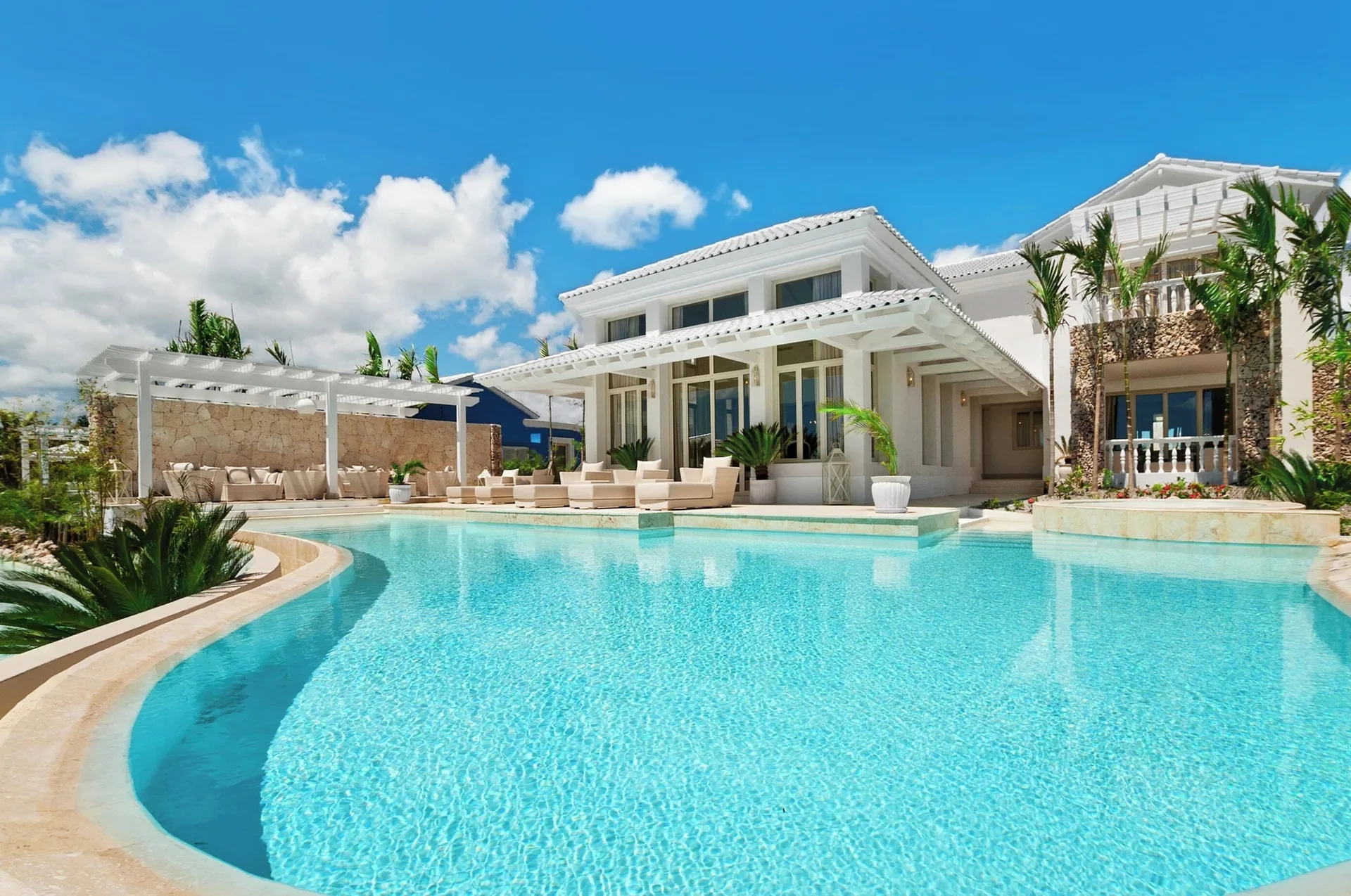Large turquoise resort pool beside white villas and palms at Eden Roc Cap Cana.